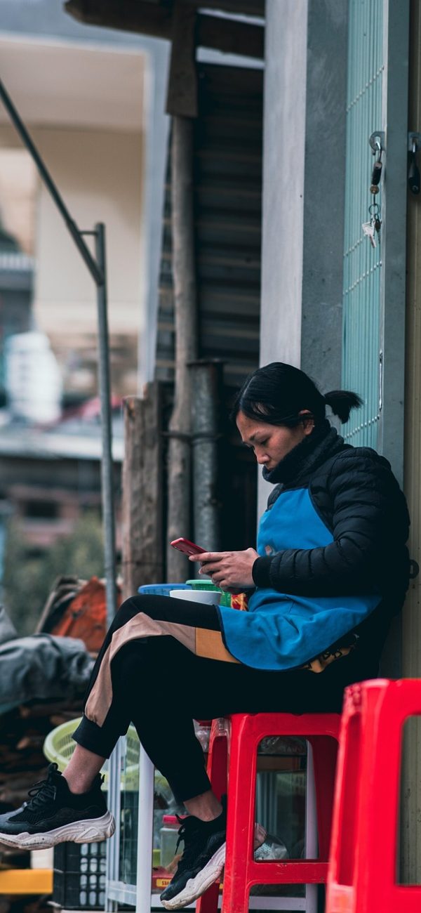 草料网 App 扫码识别界面，手机摄像头对准一张设备铭牌上的二维码正在读取内容
